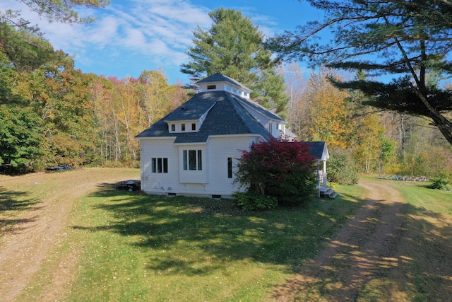 view of side of home with a yard