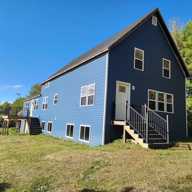 rear view of house with a lawn and a deck