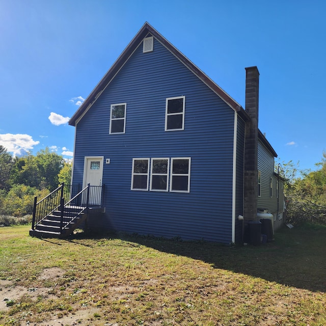 rear view of house featuring a yard