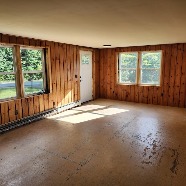 spare room featuring wood walls and baseboard heating