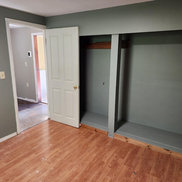 unfurnished bedroom with a closet and light hardwood / wood-style floors