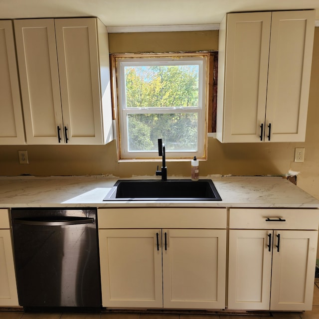 kitchen featuring light stone counters, white cabinets, sink, and stainless steel dishwasher