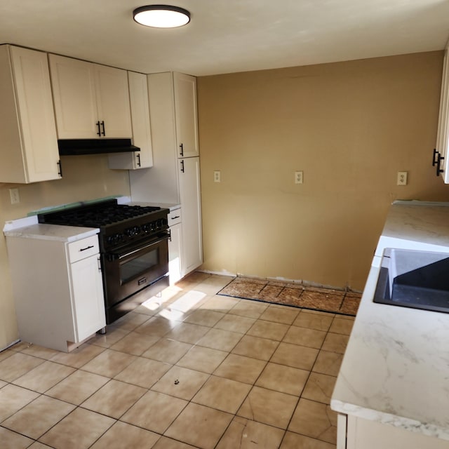 kitchen featuring white cabinetry, high end black range, and light tile patterned flooring