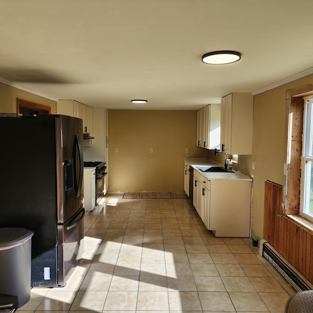 kitchen with stove, light tile patterned floors, sink, ornamental molding, and stainless steel refrigerator with ice dispenser