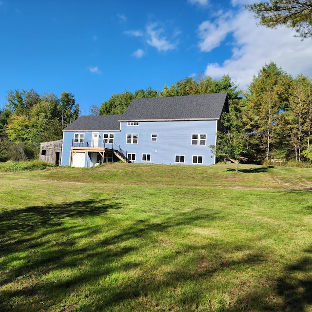 rear view of property featuring a lawn and a wooden deck