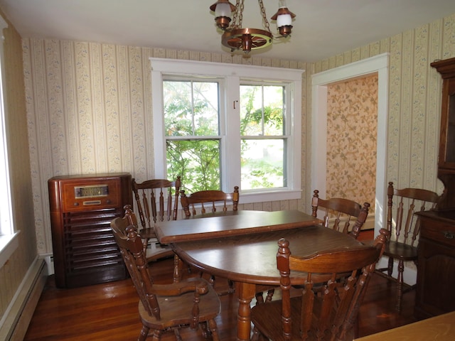 dining area featuring dark hardwood / wood-style floors, a chandelier, and a baseboard heating unit