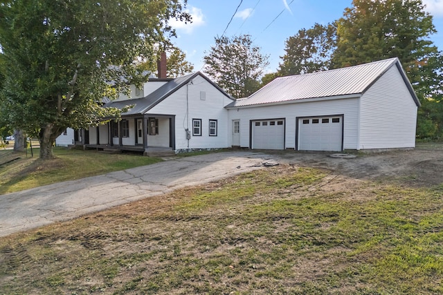 view of front of house with a front yard, a garage, and covered porch