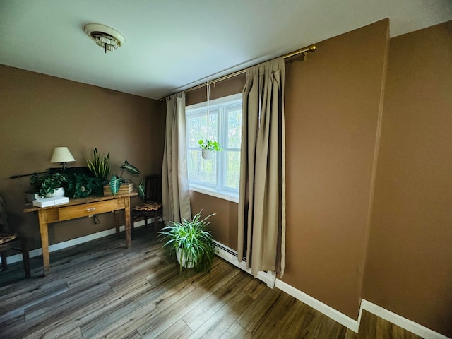 living area with wood finished floors, baseboards, and a baseboard radiator