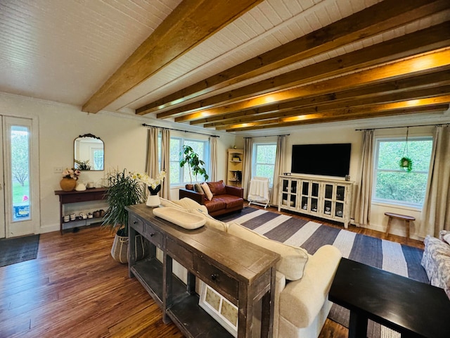 living area featuring beamed ceiling, baseboards, and wood finished floors