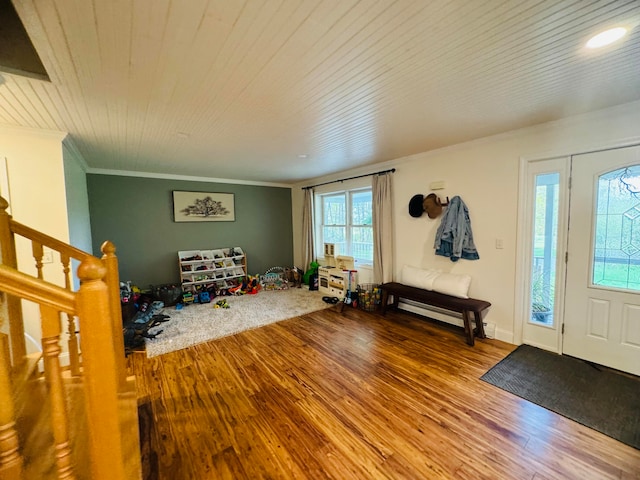 entrance foyer with stairs, wooden ceiling, wood finished floors, and ornamental molding