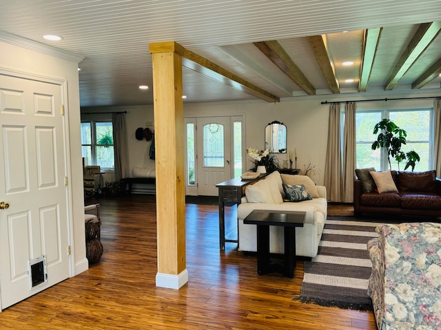 living area featuring a wealth of natural light, beam ceiling, and wood finished floors