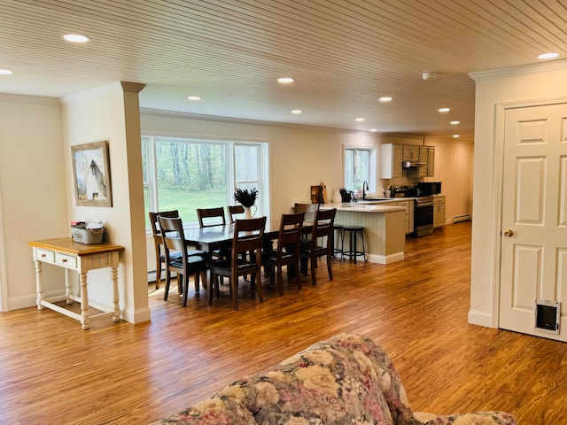 dining area with crown molding, recessed lighting, wood finished floors, and baseboards