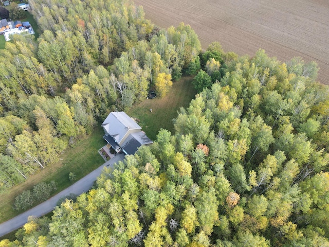 bird's eye view with a wooded view