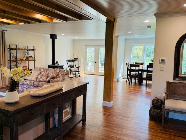 living room with a healthy amount of sunlight, french doors, a wood stove, and wood finished floors