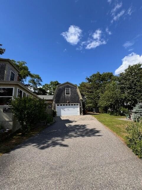 exterior space featuring a gambrel roof, driveway, and a garage