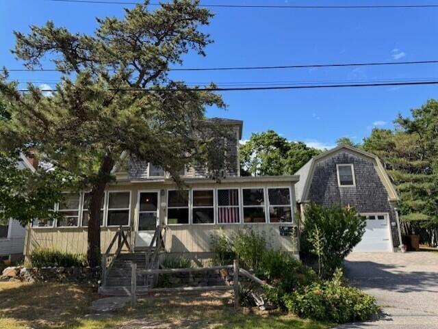 view of front of property featuring a gambrel roof, a garage, and driveway