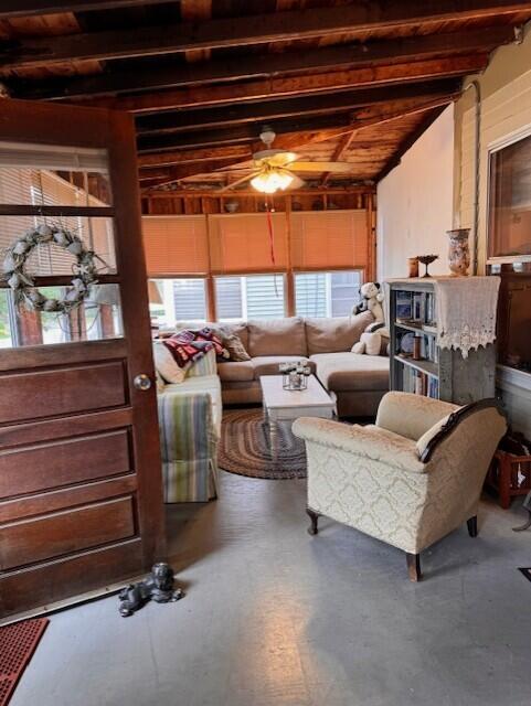 living room with beam ceiling and ceiling fan