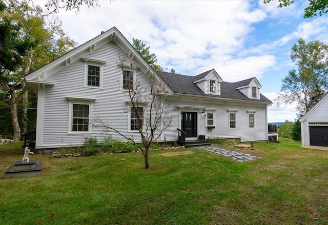 back of property with a garage and a lawn