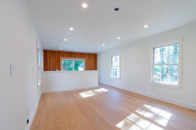 unfurnished room featuring light wood-type flooring and a healthy amount of sunlight