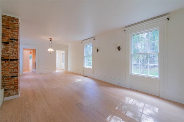 unfurnished living room with a healthy amount of sunlight and light hardwood / wood-style floors