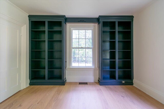 interior space featuring ornamental molding and light wood-type flooring