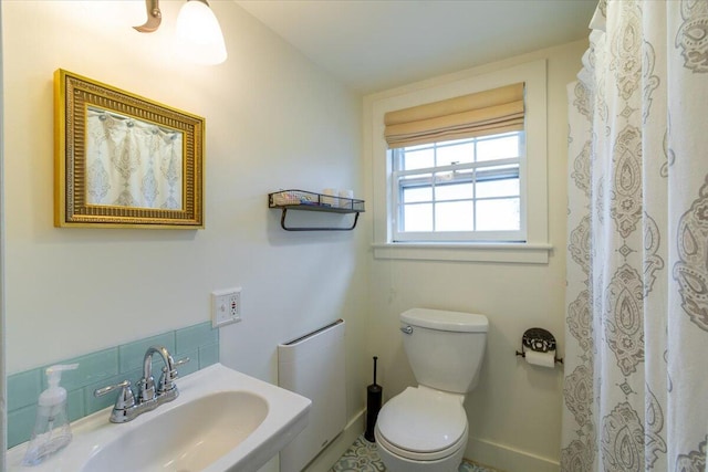 bathroom featuring sink, tasteful backsplash, and toilet