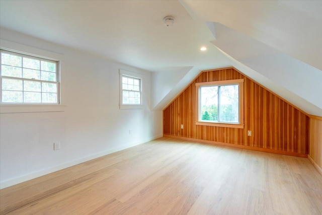 bonus room with vaulted ceiling, light hardwood / wood-style flooring, and a wealth of natural light