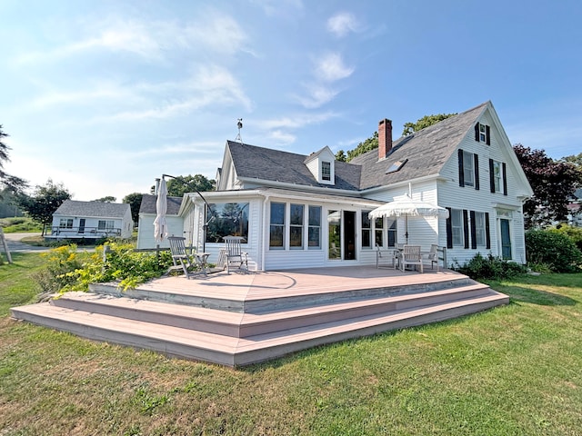 back of house featuring a lawn and a wooden deck