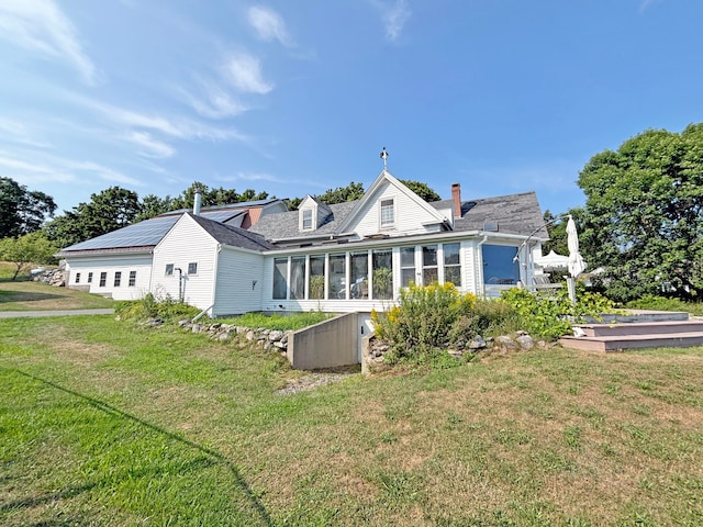 back of property featuring a sunroom and a yard