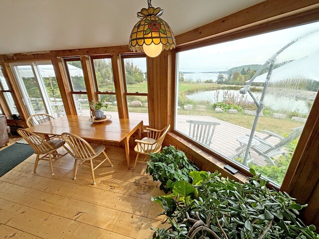 sunroom featuring a wealth of natural light and a water view