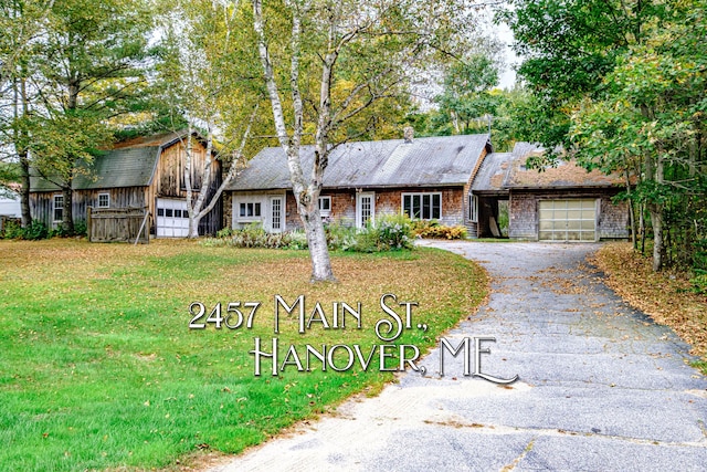 2457 Main St, Hanover, ME 04237 - view of front of property with asphalt driveway, a garage, a front lawn, and a barn