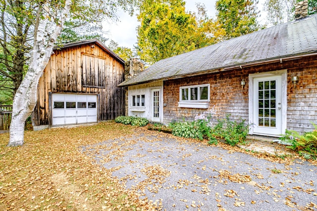 2457 Main St, Hanover, ME 04237 - view of front of property with a chimney, a garage, driveway, and an outdoor structure