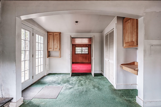 entryway featuring lofted ceiling and dark carpet