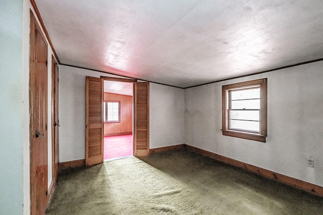 carpeted empty room with lofted ceiling and a textured ceiling