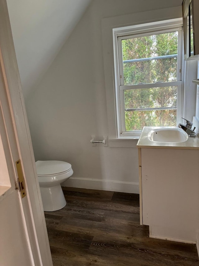 bathroom featuring hardwood / wood-style floors, vanity, toilet, and lofted ceiling