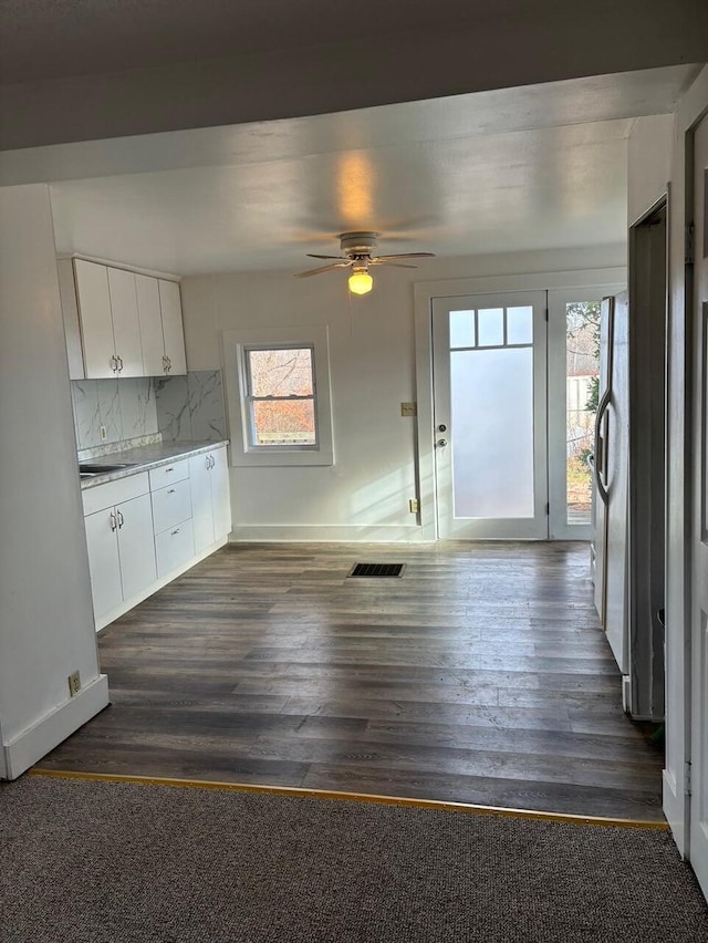 kitchen with white cabinets, dark hardwood / wood-style flooring, and a wealth of natural light