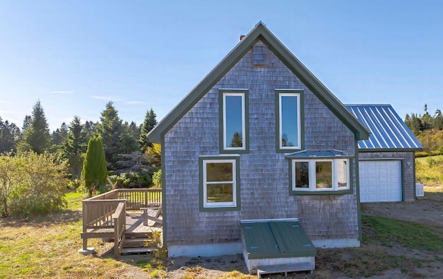 view of property exterior with a deck and a garage