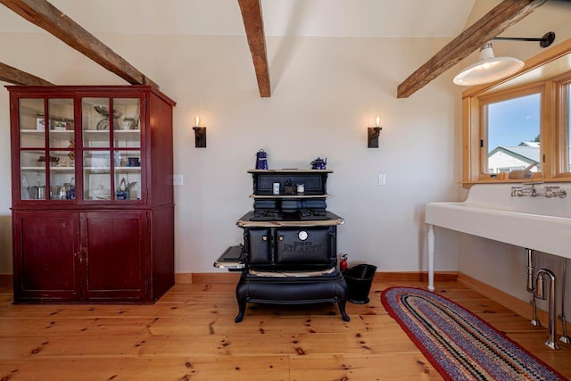 miscellaneous room featuring vaulted ceiling with beams and light hardwood / wood-style floors