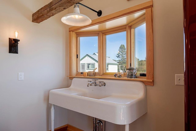 bathroom featuring sink and beam ceiling