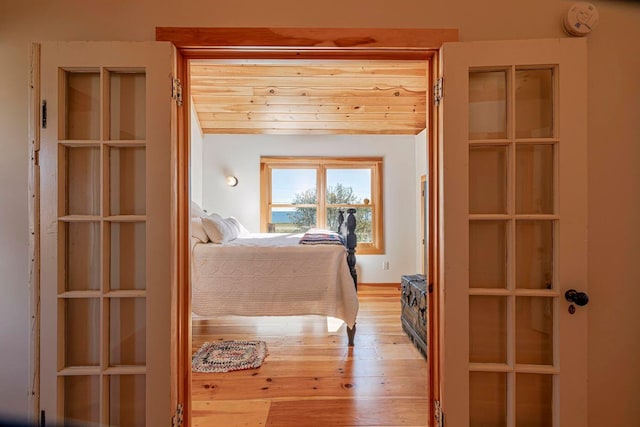 bedroom featuring light wood-type flooring and wooden ceiling