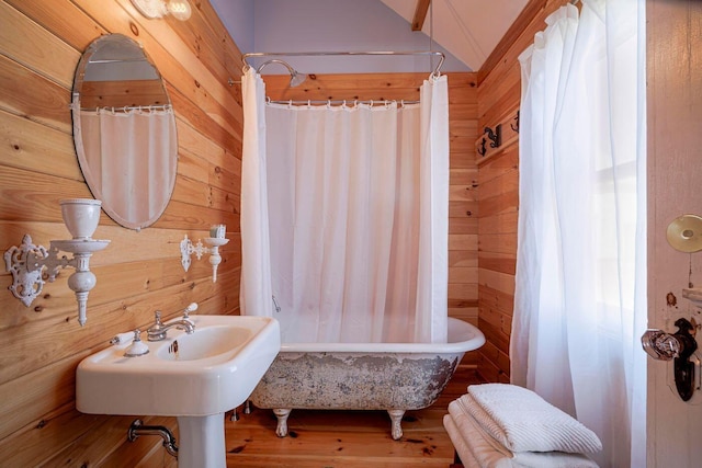 bathroom with wood-type flooring and wooden walls