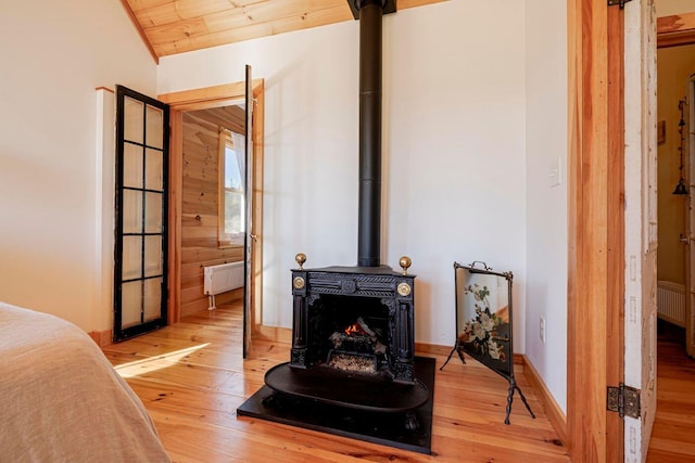 interior space with wood ceiling, wooden walls, hardwood / wood-style floors, and radiator heating unit