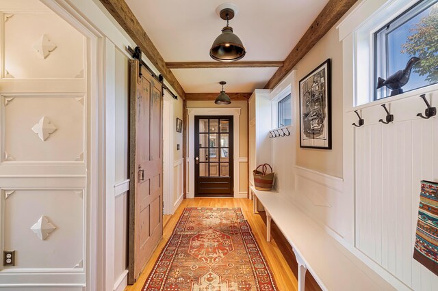 87 Carter Point Rd, Sedgwick, ME 04676 - mudroom with a barn door, light wood-style floors, healthy amount of natural light, beam ceiling, and a decorative wall