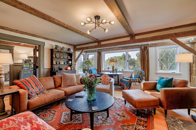 87 Carter Point Rd, Sedgwick, ME 04676 - living area featuring wood finished floors, a chandelier, and beam ceiling