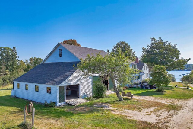 87 Carter Point Rd, Sedgwick, ME 04676 - view of home's exterior with a shingled roof, a lawn, and an outbuilding