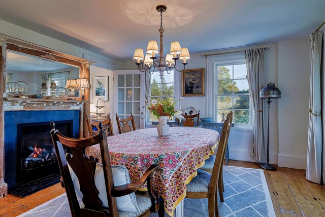 87 Carter Point Rd, Sedgwick, ME 04676 - dining room featuring hardwood / wood-style flooring, a chandelier, baseboards, and a high end fireplace