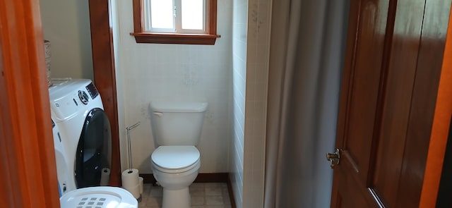 bathroom featuring toilet and washing machine and clothes dryer