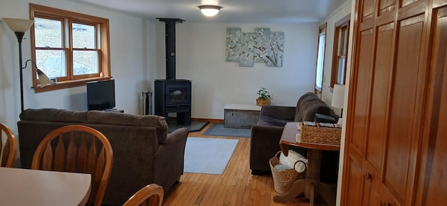 living room featuring light hardwood / wood-style flooring and a wood stove