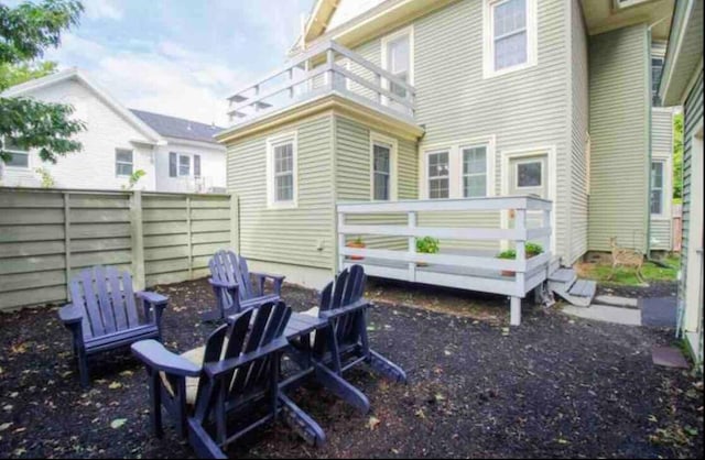 back of house with a balcony and a fire pit