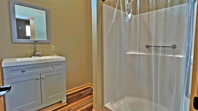 bathroom featuring wood-type flooring, vanity, and a shower with shower curtain